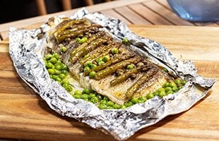 Grilled Norwegian cod in papillote with capers and asparagus