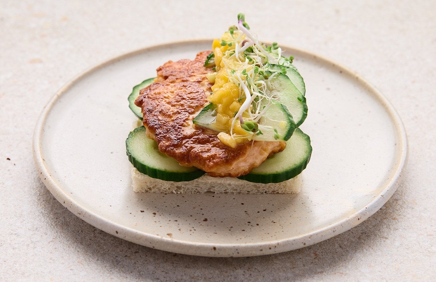 Open salmon patty sandwich with mango sauce